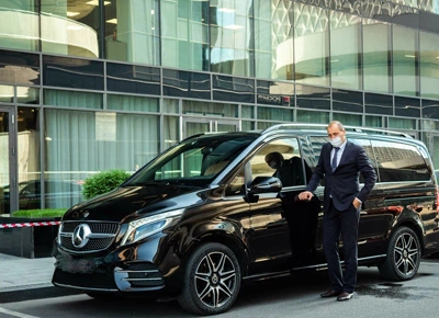 Professional Chauffeur in Front of a Luxury Black SUV